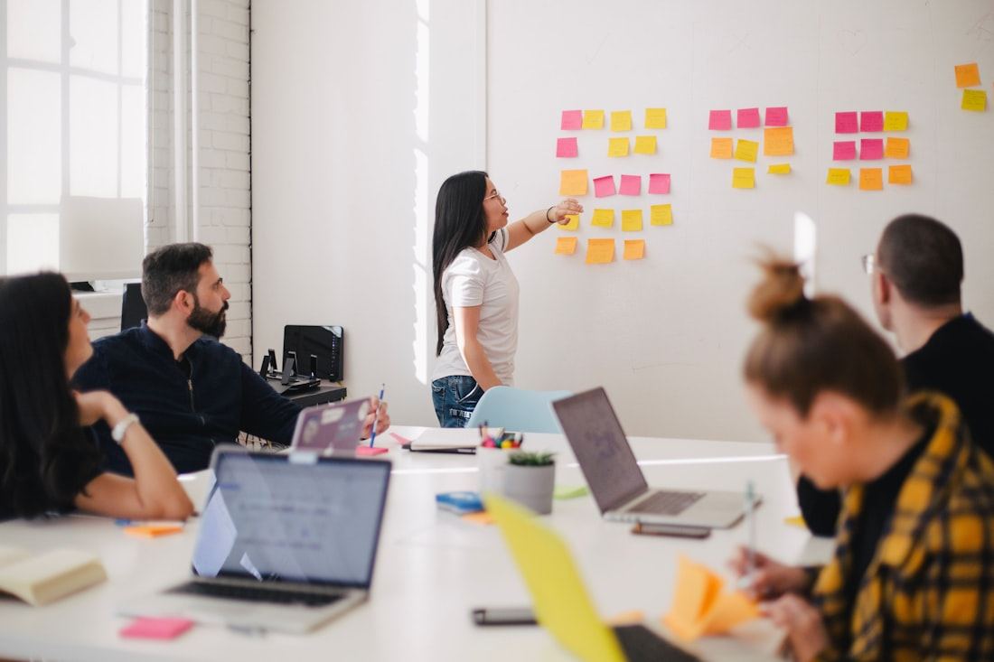 A sales team collaborating around a laptop